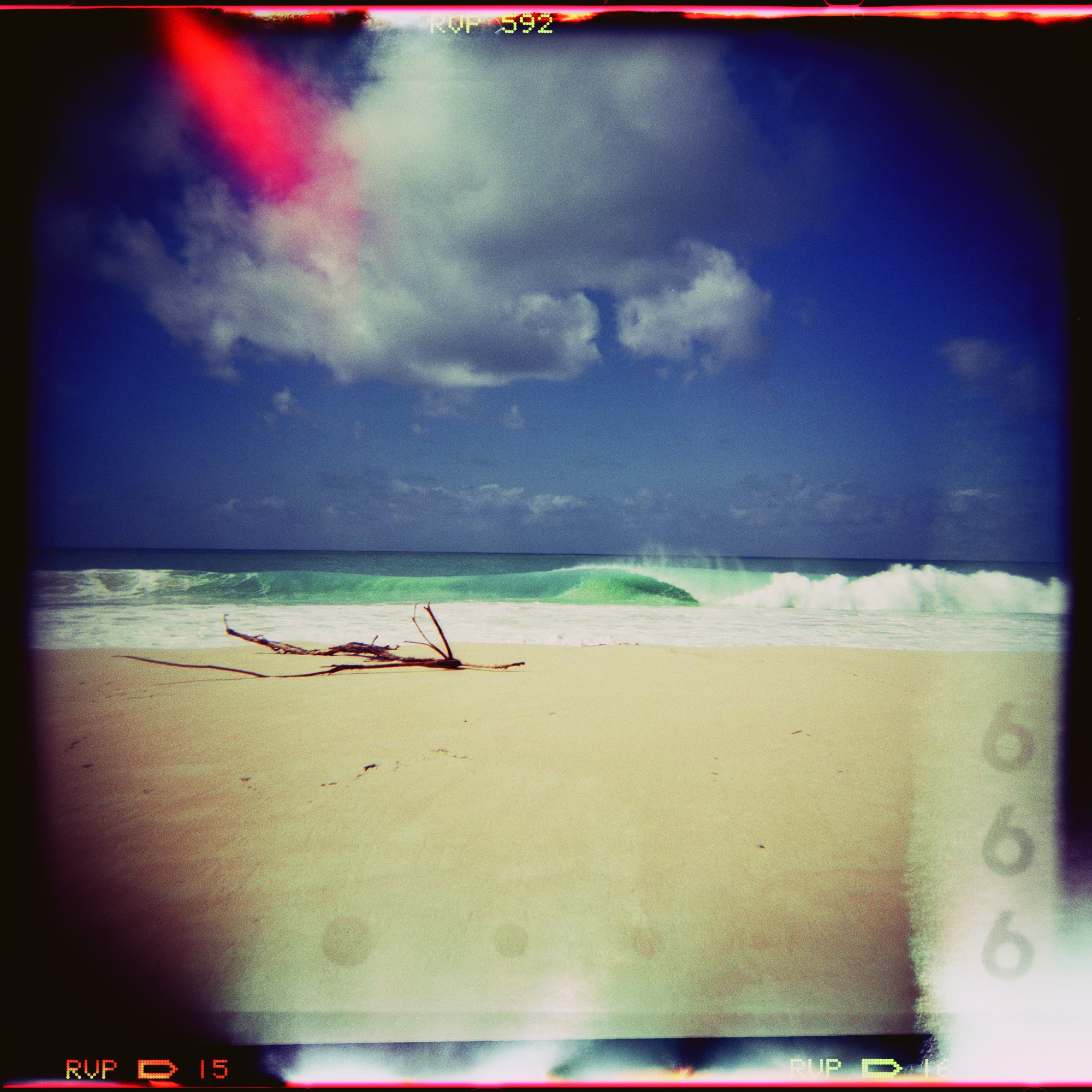 Film photograph of a breaking wave on a sandy beach